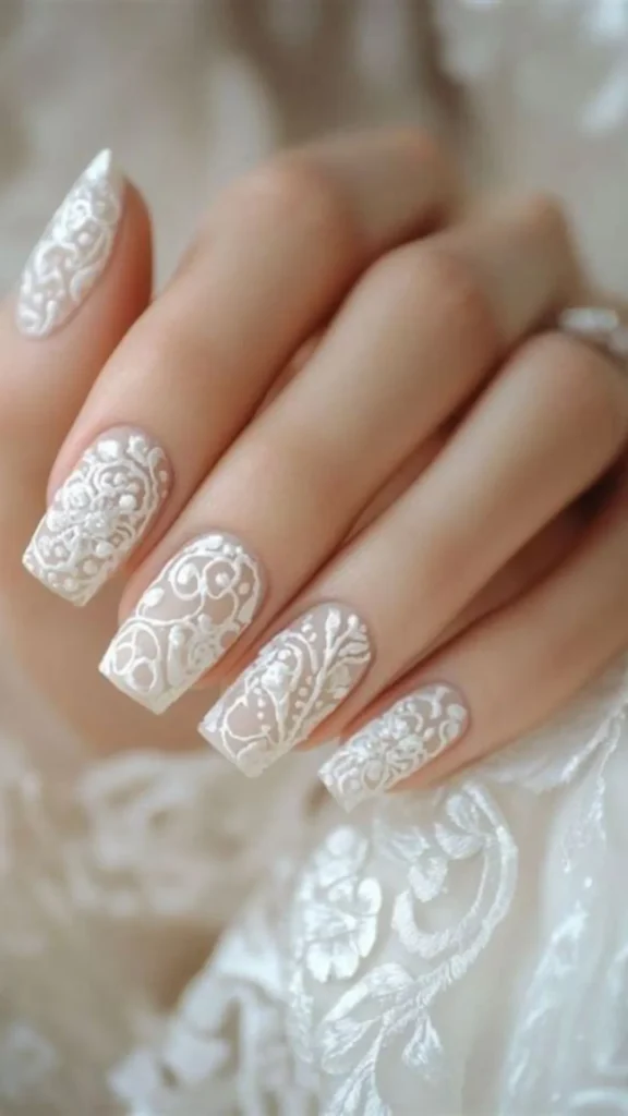An elegant hand showcasing square nails with a translucent nude base decorated with textured, raised 3D white gel scrollwork and delicate baroque lace patterns.