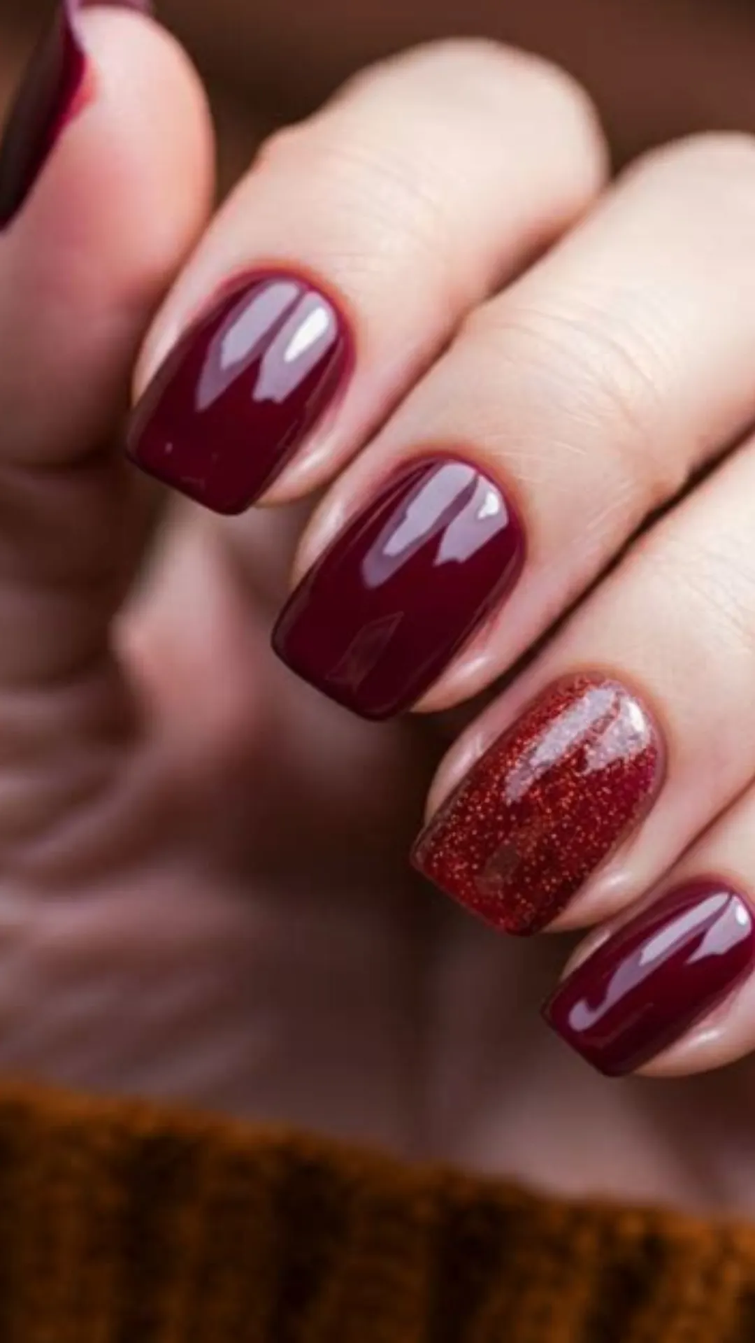 A classic and elegant fall manicure featuring glossy, deep burgundy square nails paired with a striking burnt-orange glitter accent nail.